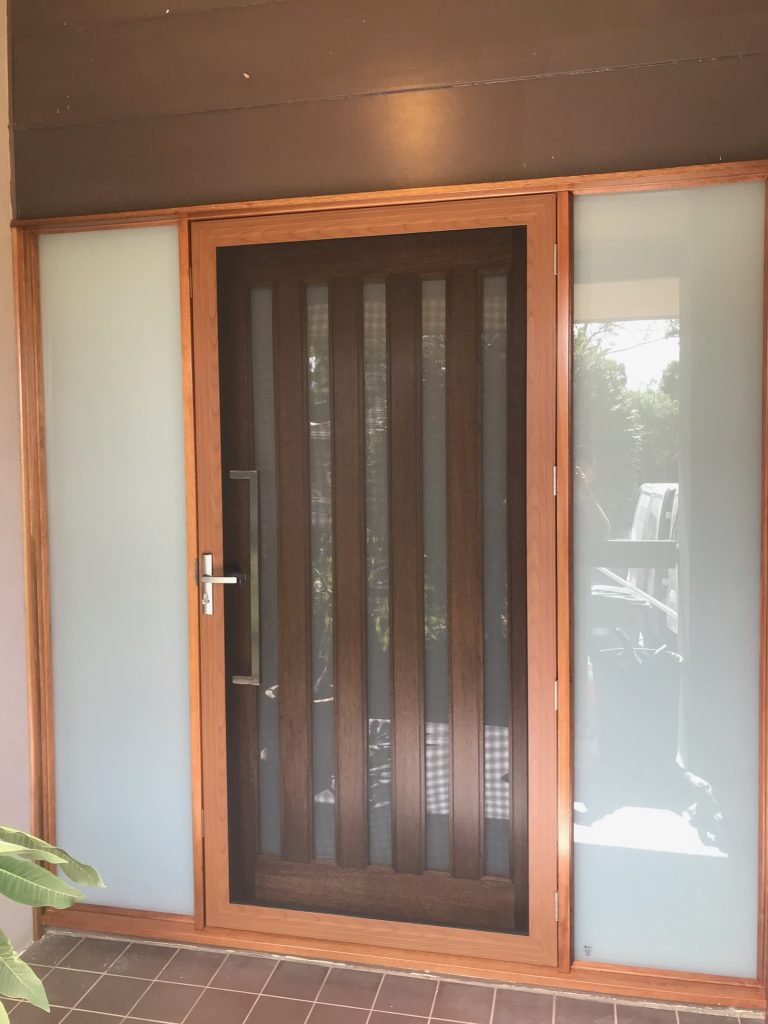 After - Large Wooden door replacement with vertical glass inserts and security screens